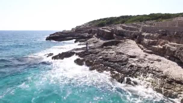 Mempelai berpelukan di pantai berbatu di Lustica — Stok Video