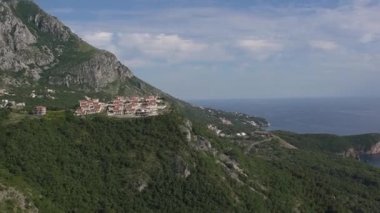 Karadağ 'da deniz kenarındaki dağlarda yeşillikler arasında evler