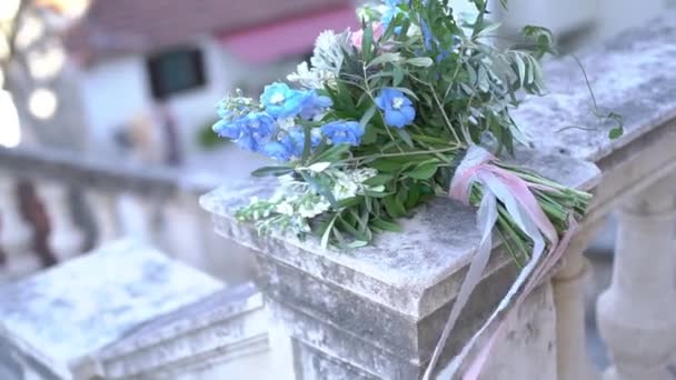 The brides bouquet lies on the wide railing of an ancient staircase — Stock Video