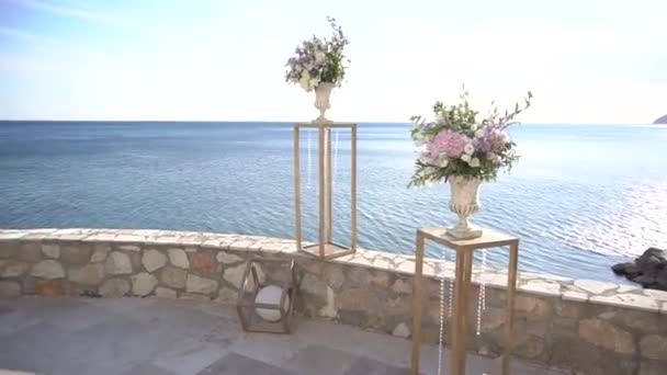 Bröllopsplats dekorationer med stativ, glas hängen och vaser med blommor — Stockvideo