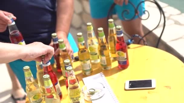 Personas toman botellas de bebidas sidra Somersby de la mesa durante una fiesta — Vídeos de Stock