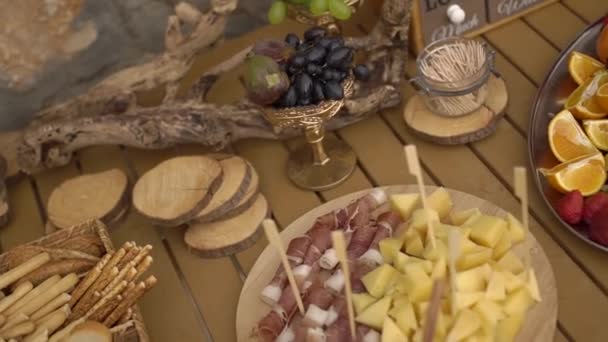 Esküvői büfé gyümölcsös rágcsálnivalókkal egy fa asztalon — Stock videók
