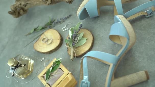Los zapatos de las novias, los anillos de boda y los accesorios se encuentran uno al lado del otro durante la preparación — Vídeos de Stock