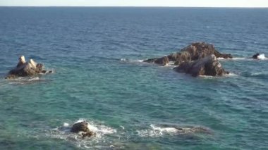 Deniz dalgalarının onlara çarptığı kayaları görüyor musun?