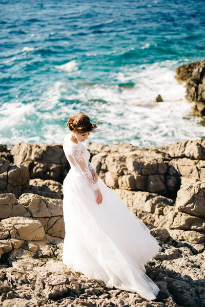 Vacker brud i anbud bröllop klänning på stenig strand Mamula ön — Stockfoto