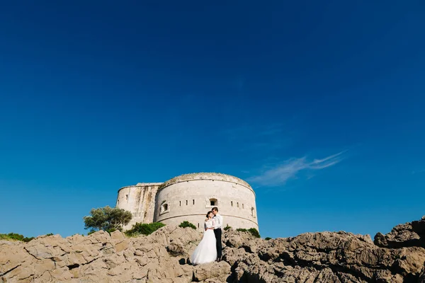 Brud och brudgum kramas nära Arza fästning på Mamula ön — Stockfoto