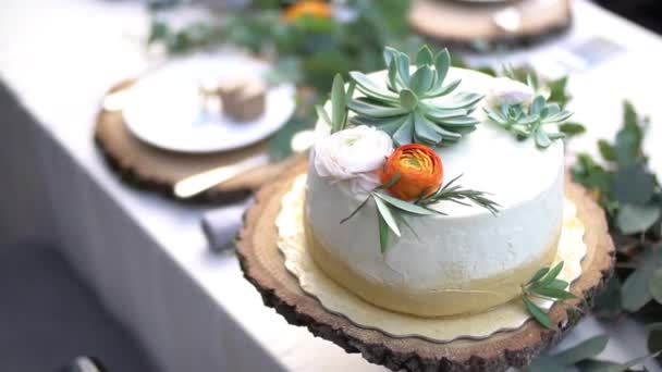 Bruidstaart versierd met bloemen op tafel op een bruiloft banket — Stockvideo