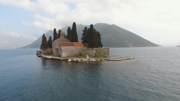 Vista dell'isola di San Giorgio vicino a Perast, sposi in piedi su di essa — Video Stock