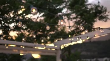 Rüzgarda sallanan dekoratif ampullerden oluşan çelenkler.