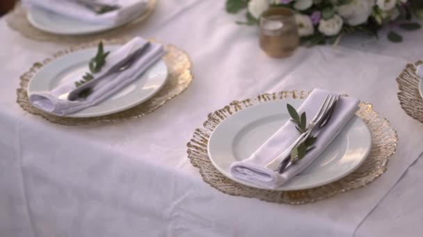 Mesa en un banquete de bodas decorado con ramas de olivo y flores de lisianthus — Vídeos de Stock