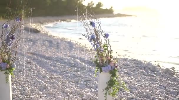 在海边的鹅卵石沙滩上，有拱门和装饰品的婚礼场地 — 图库视频影像