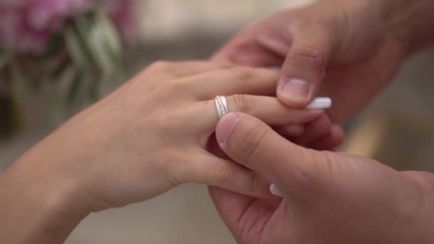 Наречений кладе кільце на палець нареченої крупним планом — стокове відео