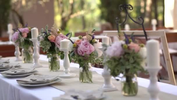 Serviço e decoração da mesa com flores e castiçais no banquete de casamento — Vídeo de Stock