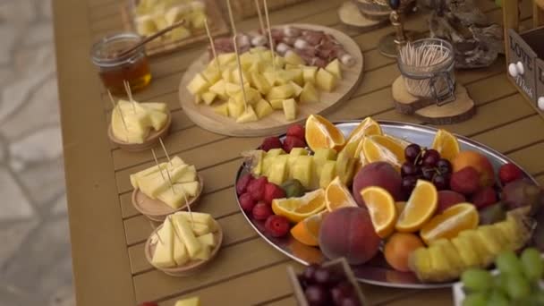 木製のテーブルの上でフルーツスナックと結婚式のビュッフェ — ストック動画