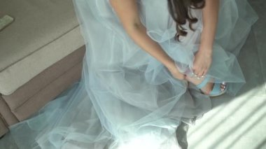 Gelin düğün hazırlıkları sırasında sandaletini ilikliyor.