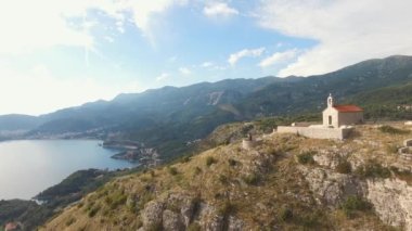 Dağlardaki eski kilisenin yakınındaki gözlem güvertesinde kucaklaşan çift. 