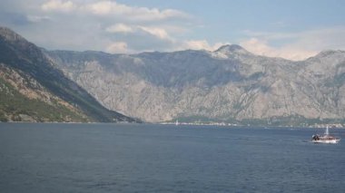 Kotor Körfezi 'nin sahil ve manzaralı dağları, dağlardaki bulutların gölgeleri, yelkenliler, zaman akıp gidiyor.