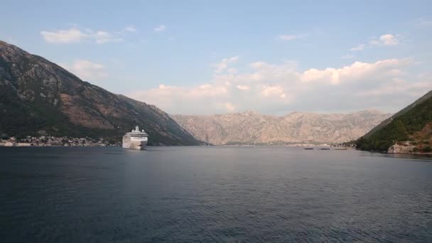 O navio de cruzeiro navega ao longo da Baía de Kotor, atrás dele há belas montanhas, timelapse — Vídeo de Stock