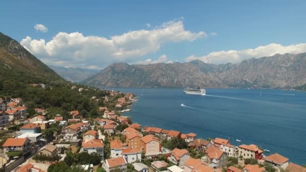 Uitzicht op de kleine stad van de baai van Kotor, prachtige bergen en een zeilschip — Stockvideo