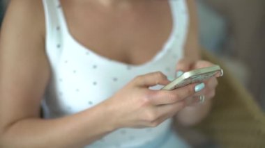 Akıllı telefondan yazı yazan bir kızın elleri. Yakın çekim.