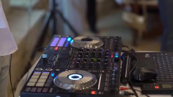 Mão do homem que está atrás da mesa de mistura DJ, DJing, faixas de mistura — Vídeo de Stock