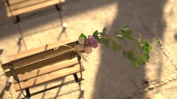 Local do casamento, cadeira decorada com rosas e ramos de eucalipto — Vídeo de Stock