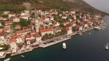 Eski Perast kasabasının manzarası, dağlar, armut ve yakınındaki tekneler. 