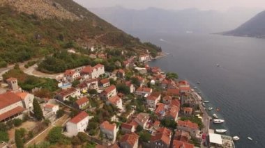 Eski Perast kasabasının manzarası, dağlar, armut ve yakınındaki tekneler. 