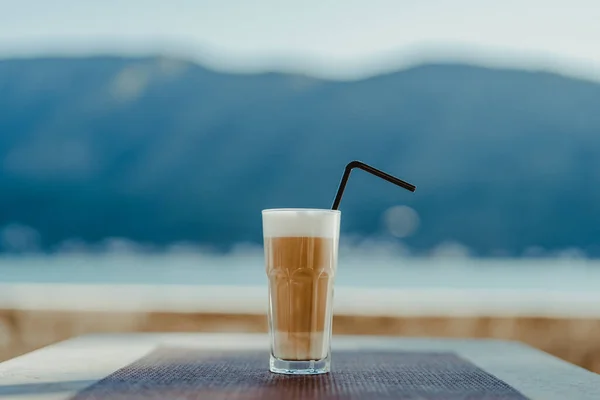 Faceted glass with coffee latte and straw. — Foto de Stock