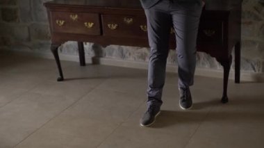 Zarif, uzun bir dolabın yanında duran bir adamın bacakları, yakın plan.