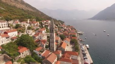 Eski Perast kasabasının manzarası, dağlar, armut ve yakınındaki tekneler. 