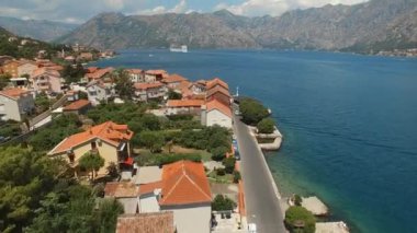 Kotor Körfezi 'nin küçük bir kasabası, güzel dağlar ve bir yelkenli gemisi.