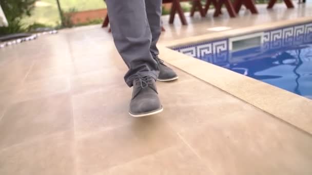Πόδια ενός άνδρα που περπατούσε κατά μήκος της πισίνας, κοντινό πλάνο — Αρχείο Βίντεο