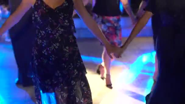手を取り、ダンスフロアで陽気なエネルギーのダンスを踊る人々 — ストック動画