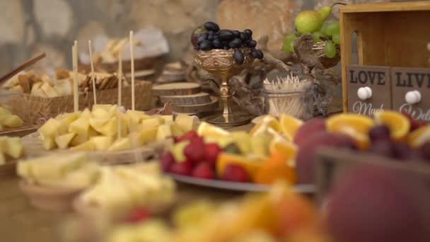 Weselny bufet z owocowymi przekąskami na drewnianym stole — Wideo stockowe
