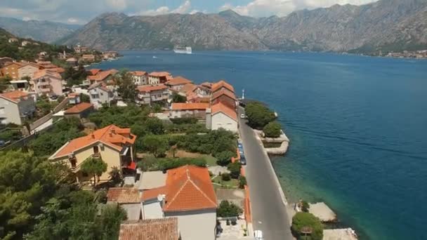 Vista de la pequeña ciudad de la Bahía de Kotor, hermosas montañas y un velero — Vídeos de Stock