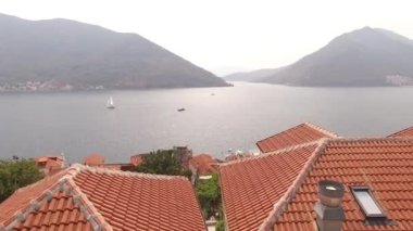 Eski Perast kasabasının manzarası, dağlar, armut ve yakınındaki tekneler. 