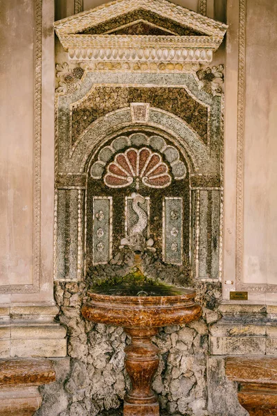 Fuente de bebida montada en la pared en el templo con una figura de un pez sobre un tazón marrón. —  Fotos de Stock