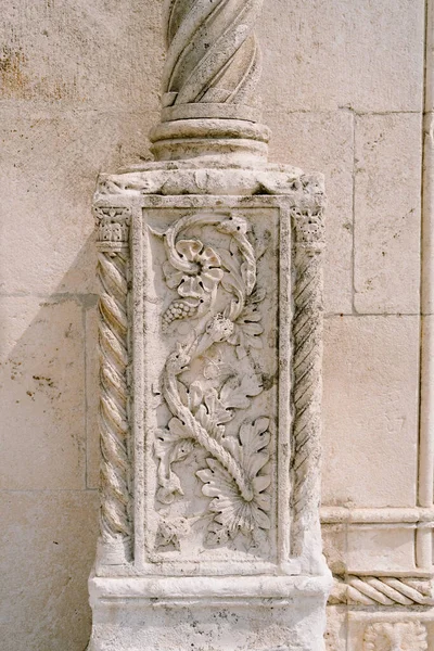 Mur en pierre avec bas-relief en forme de fleur sur une colonne. — Photo