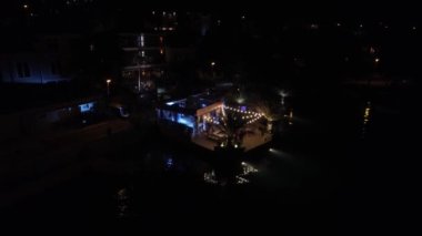 Sahildeki bir restoranda düğün partisi, dans pistinde dans eden insanlar.