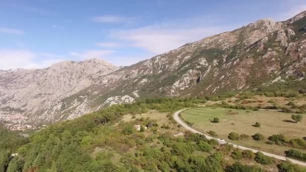 Fehér kabriók egy festői hegyi szerpentin mentén a Lovcen-hegyen — Stock videók