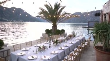 Kotor Körfezi 'ndeki iskelede çiçeklerle, şamdanlarla ve genç narlarla süslenmiş bir düğün yemeğinde bir masa.