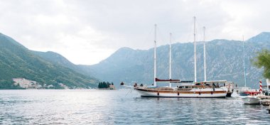 Karadağ 'ın Perast kentindeki iskeleye demirlemiş iki direkli büyük yatlar.