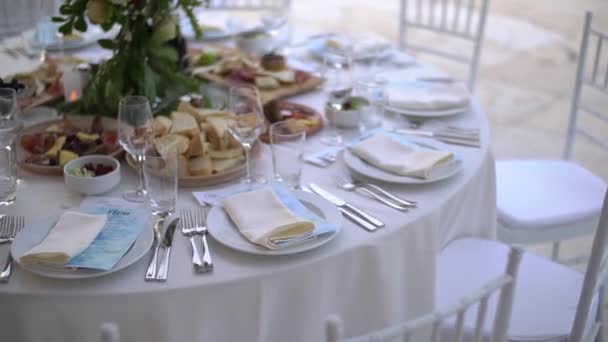 Servírovací stůl zdobený kyticí květin a elegantními bílými židlemi na svatební hostině — Stock video
