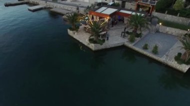 Deniz kıyısında güzel bir restoran, parlak çelenkler ve Kotor Körfezi 'ndeki iskelede bir düğün ziyafeti.