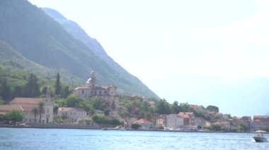 Kotor Körfezi 'ndeki Prcanj kasabasının kıyı şeridine ve oradan geçen bir motorlu tekneye bakın.