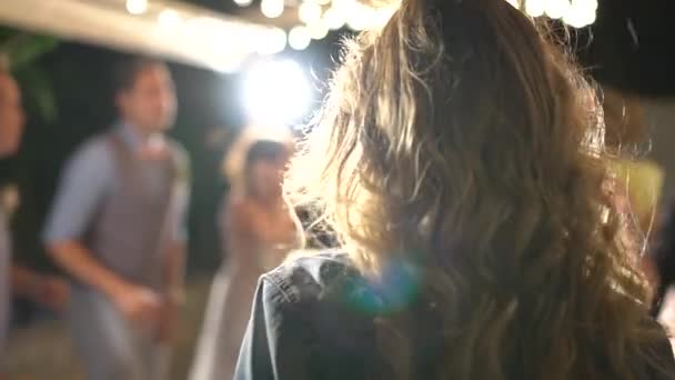 Girl dancing in the spotlight, her hair fluttering, view from the back — Stock Video