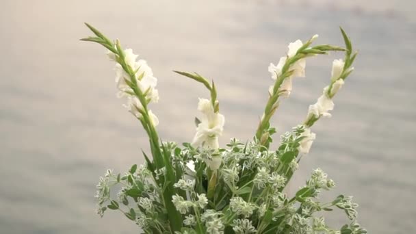 Bukett med vita blommor på bakgrunden av havet - bröllop dekoration — Stockvideo