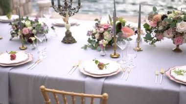 Kotor Körfezi 'ndeki iskelede çiçeklerle, şamdanlarla ve genç narlarla süslenmiş bir düğün yemeğinde bir masa.