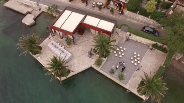 Άνετο εστιατόριο δίπλα στη θάλασσα και γαμήλιο δείπνο στην προβλήτα του κόλπου του Κότορ, θέα στην κορυφή — Αρχείο Βίντεο
